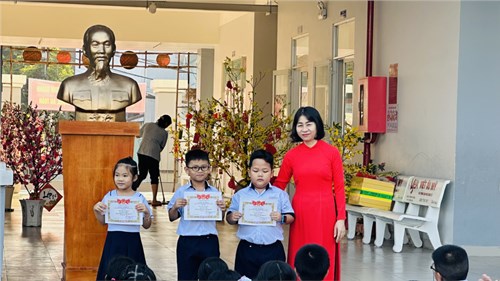 Các em học sinh Trường Tiểu học Trần Quốc Toản sinh hoạt dưới cờ về chủ đề ở nhà vui tết, tổ chức trao giải Hội thi Trang trí cây mai, cây đào, gian hàng ẩm thực thực hiện theo kế hoạch Mừng Đảng Mừng Xuân